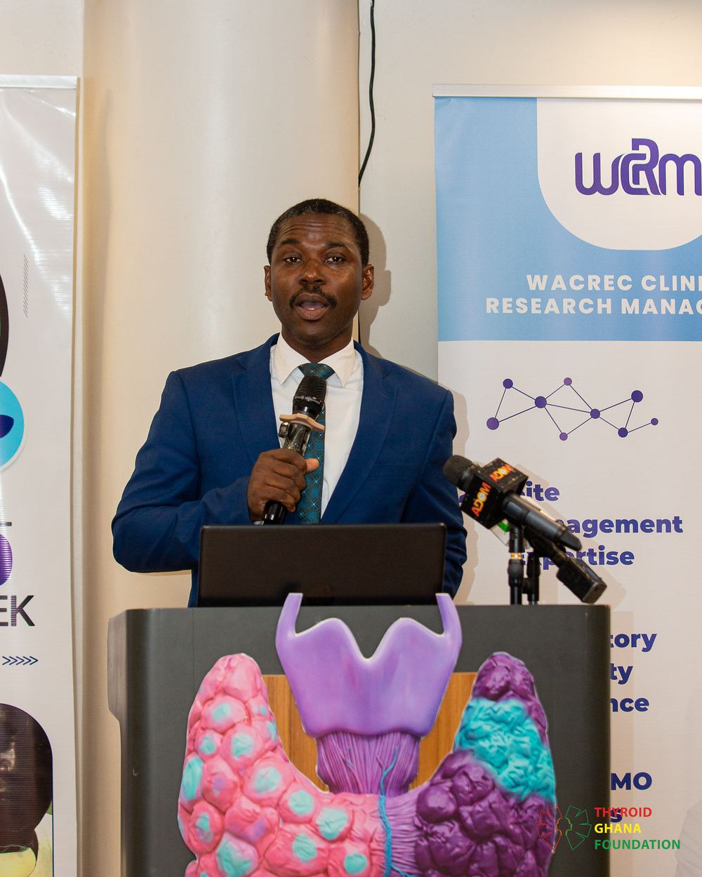 A presenter beside the thyroid model at International Thyroid Awareness Week 2026.