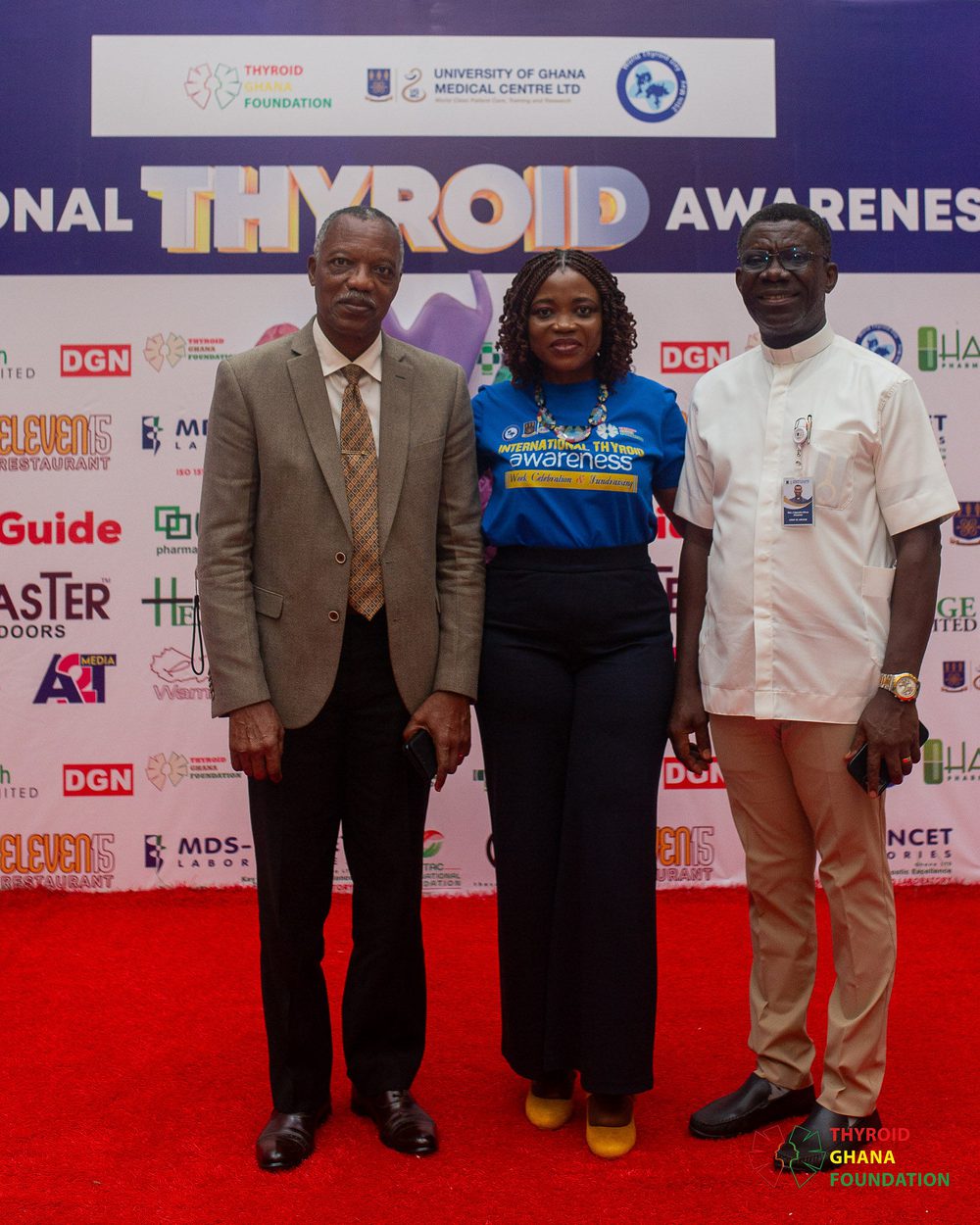 The Foundation’s founder with two guests on the red carpet in front of the event backdrop.